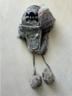 Gorro aviador gris de camuflaje con calavera, orejeras suaves y pompones en los extremos de cintas largas