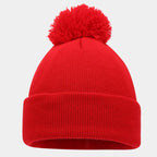 Gorro rojo con vuelta ancha de canalé y pompón de hilo rojo, fotografiado sobre fondo blanco