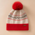 Gorro color crema con motivo nórdico, vuelta roja de canalé y pompón grande del mismo rojo