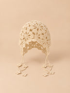 Gorro beige de rejilla calada para anudar, con cintas que permiten ajustar la sujeción, vista frontal