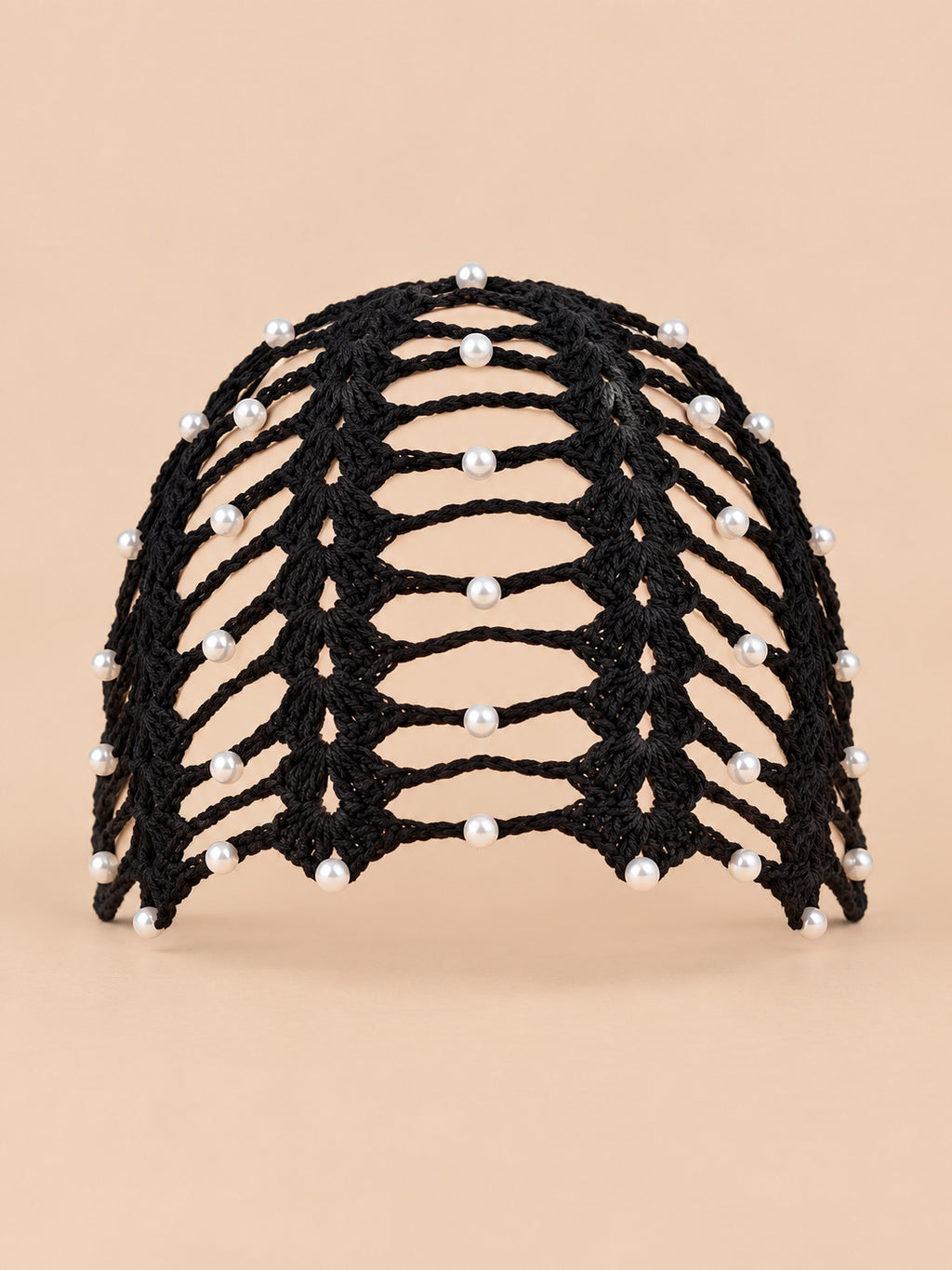 Bonnet bandana femme noir au crochet ajouré perlé, vue de face sur fond pêche sable