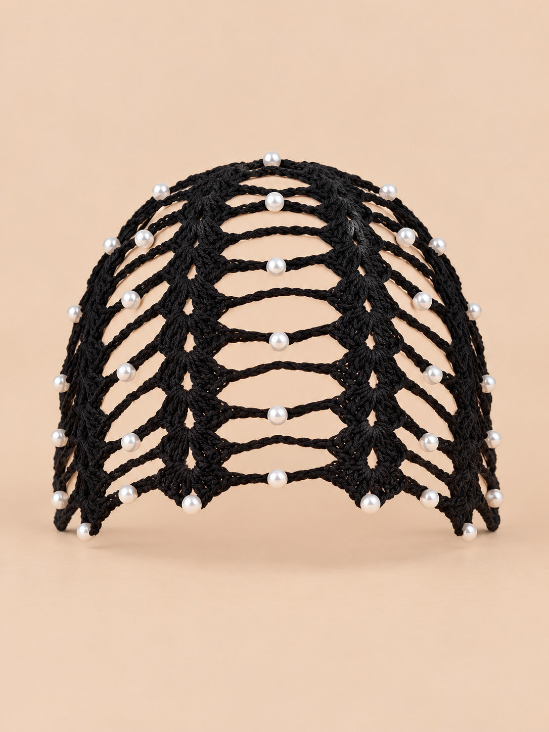 Bonnet bandana femme noir au crochet ajouré perlé, vue de face sur fond pêche sable