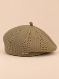 Béret ajouré style japonais kaki, vue de face sur fond pêche sable
