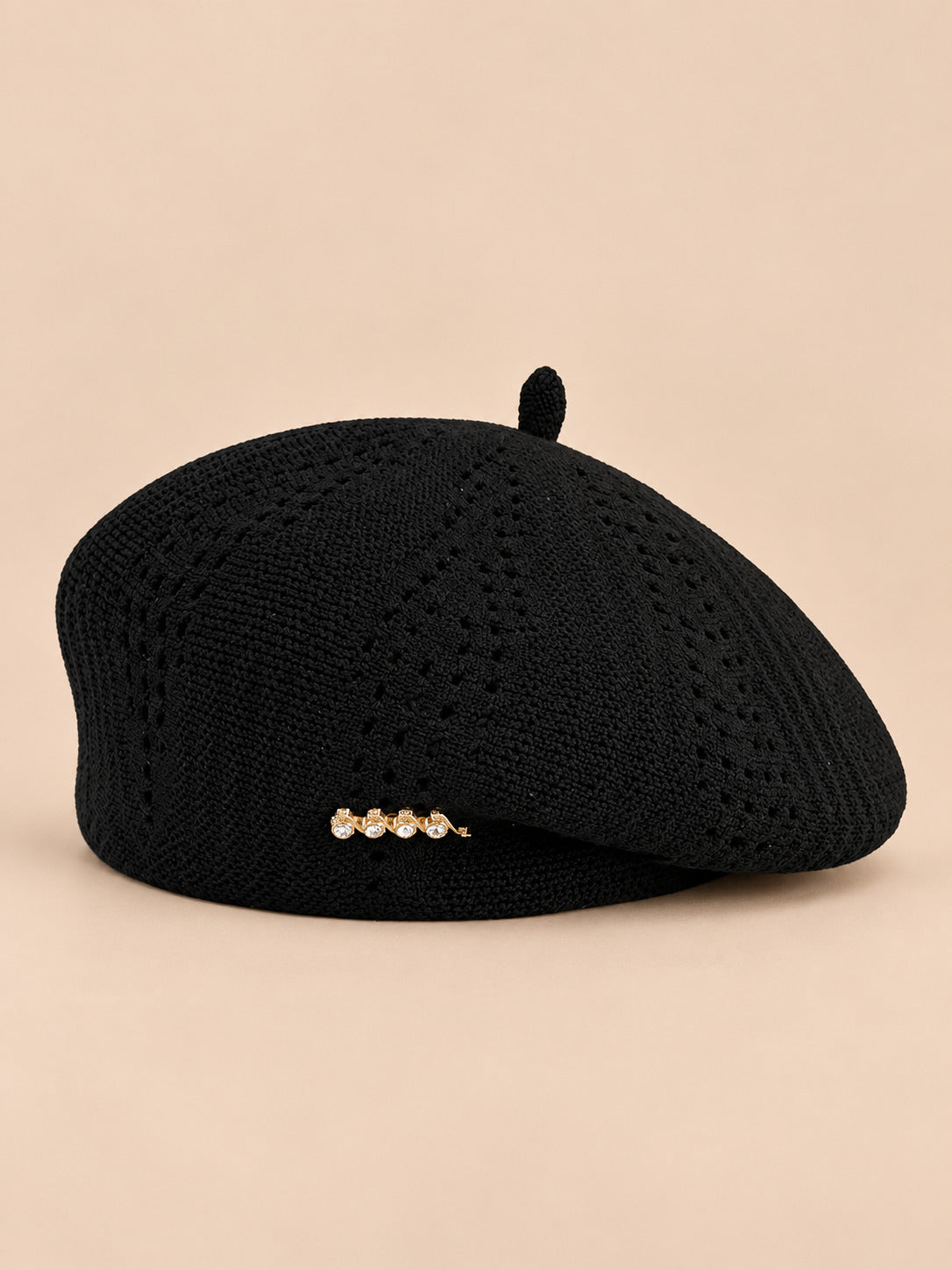 Béret ajouré style japonais noir, vue de face sur fond pêche sable