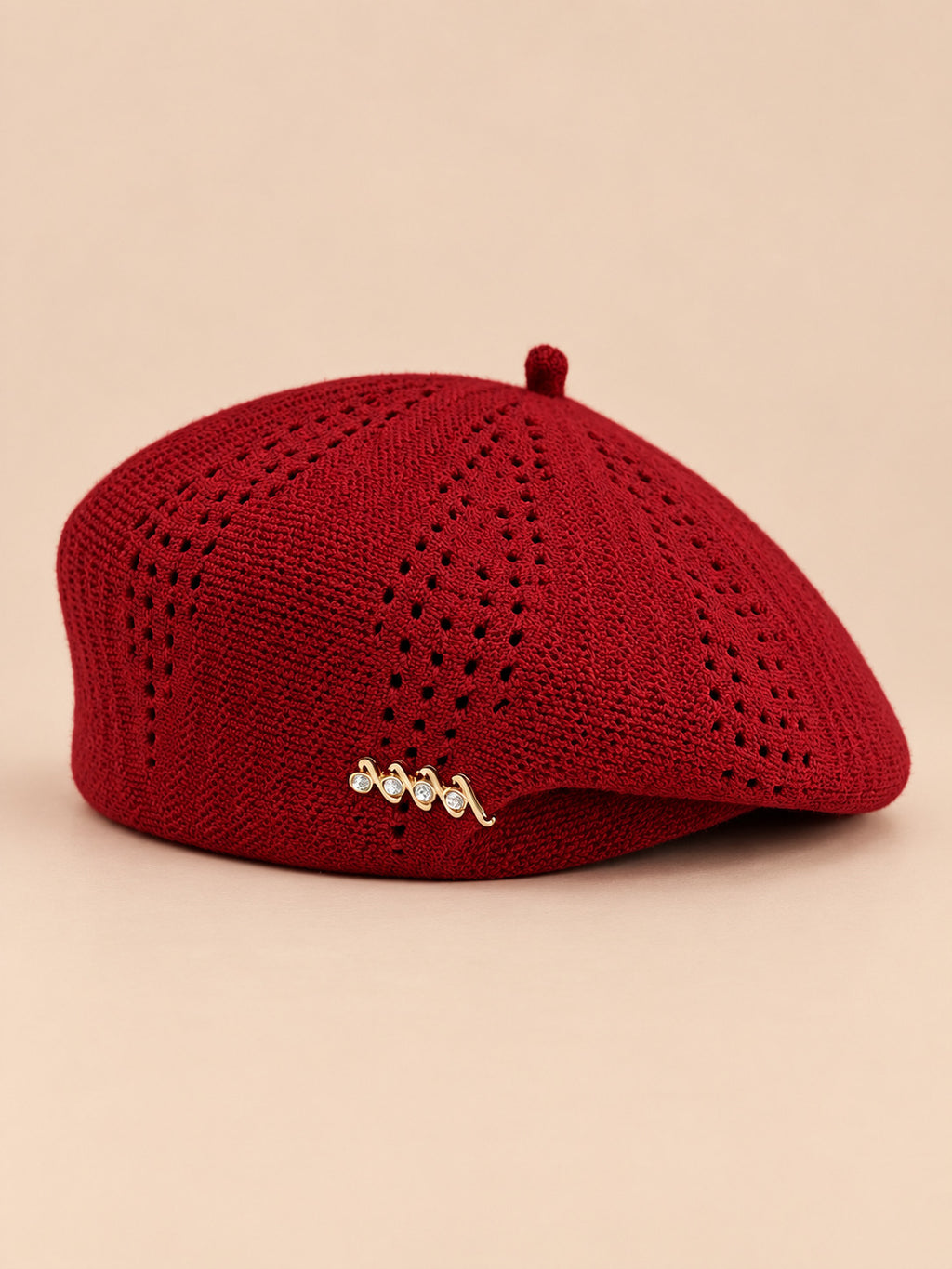 Béret ajouré style japonais rouge, vue de face sur fond pêche sable