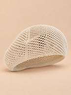 Béret d’artiste ajouré beige, vue de face sur fond pêche sable