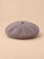 Béret d’artiste femme en laine mélangée vintage, coloris 012, vue de face sur fond sable pêche.