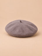 Béret d’artiste femme en laine mélangée vintage, coloris 012, vue de trois quarts sur fond sable pêche.