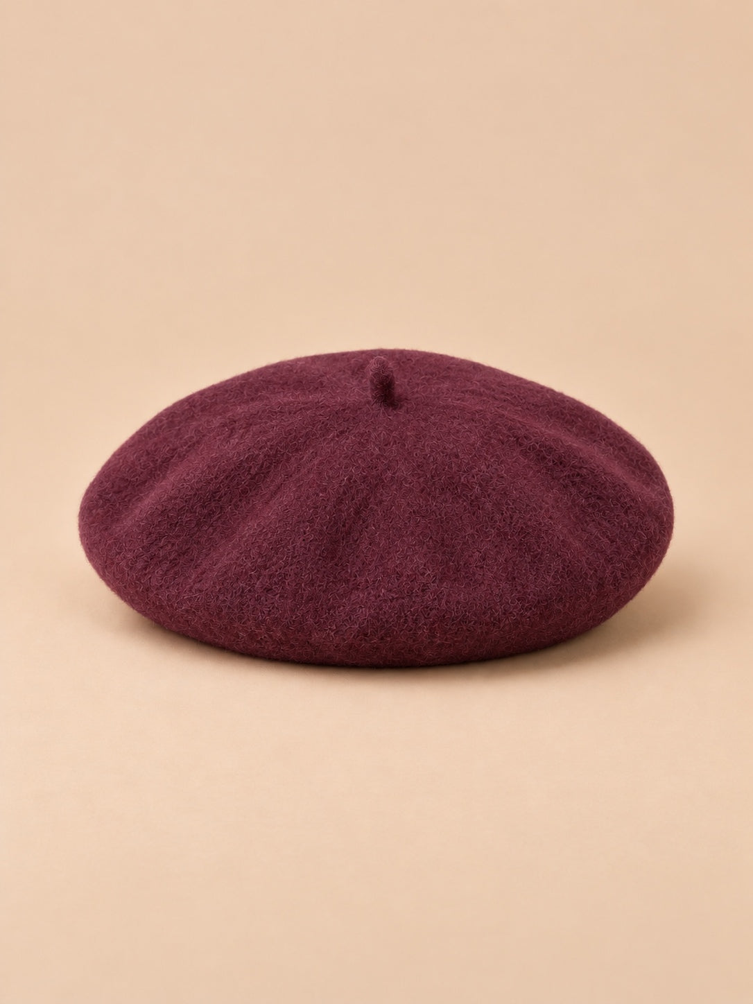 Béret d’artiste femme en laine mélangée vintage, coloris 019, vue de face sur fond sable pêche.