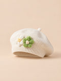 Béret bébé fille Beige à fleurs en relief au crochet, vue de face sur fond pêche sable