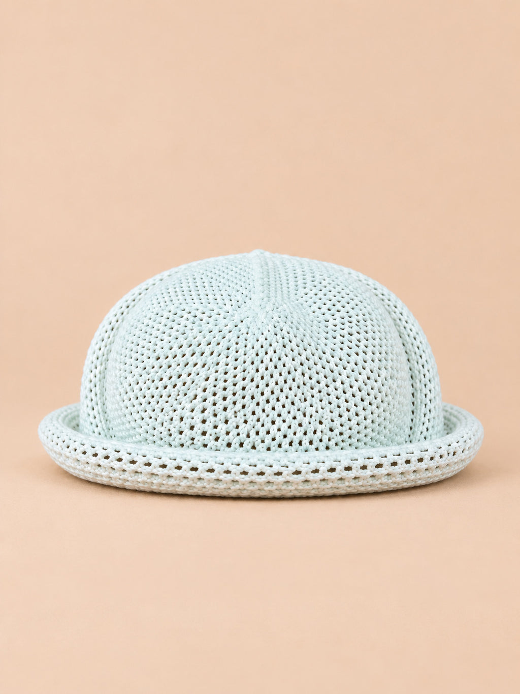 Béret bibi ajouré blanc, vue de face sur fond pêche sable