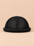 Béret bibi ajouré noir, vue de face sur fond pêche sable
