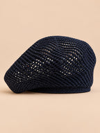 Béret bibi résille bleu nuit, vue de face sur fond pêche sable