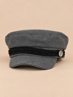 Gorra marinera de ocho paneles, estilo capitán, color gris, vista frontal, sobre fondo color arena y melocotón