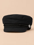 Béret casquette de marin noir, vue de face sur fond pêche sable