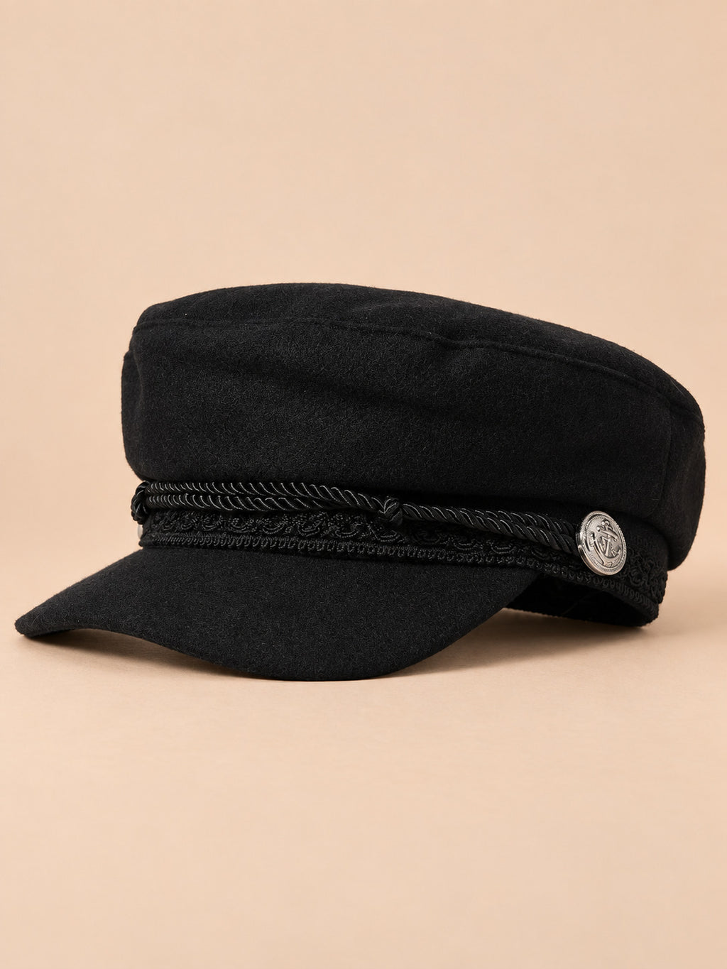 Béret casquette de marin noir, vue de trois quarts sur fond pêche sable
