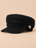 Béret casquette de marin noir, vue de trois quarts sur fond pêche sable