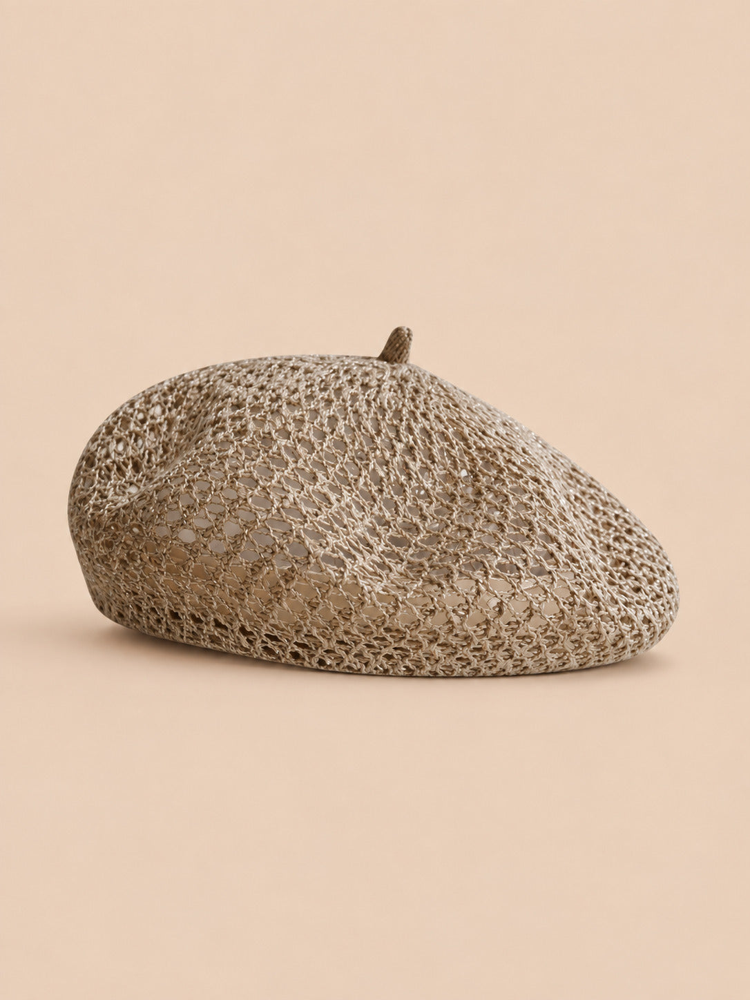 Béret citrouille ajouré kaki, vue de face sur fond pêche sable