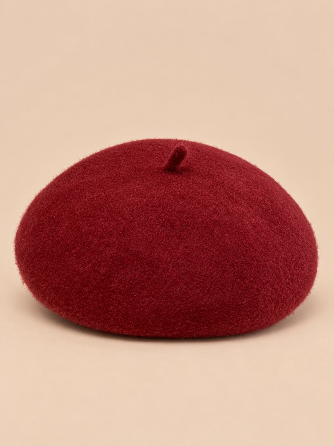 Béret français femme en pure laine bordeaux, vue de face sur fond beige