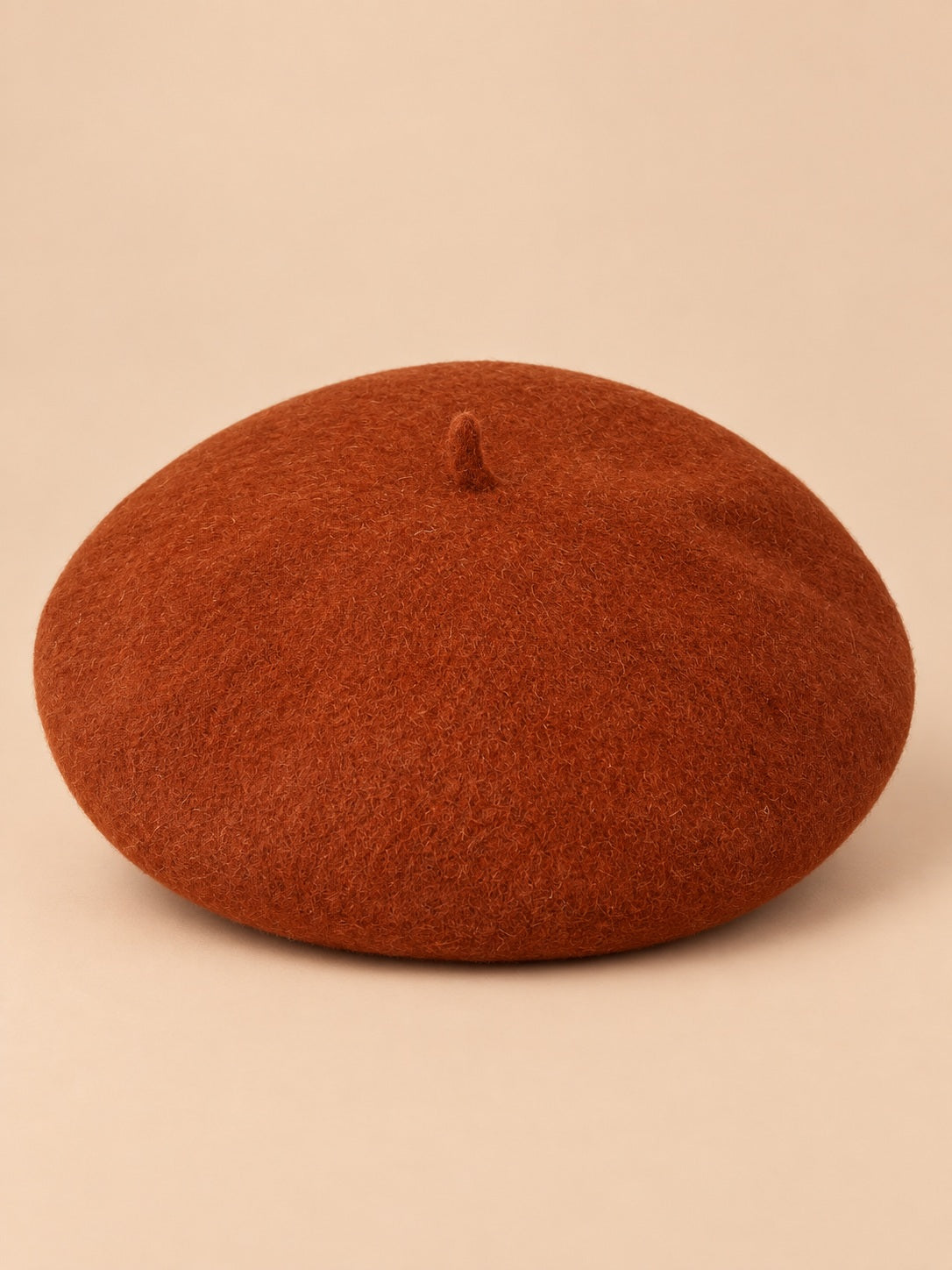 Béret français femme en pure laine rouge brique, vue de face sur fond beige