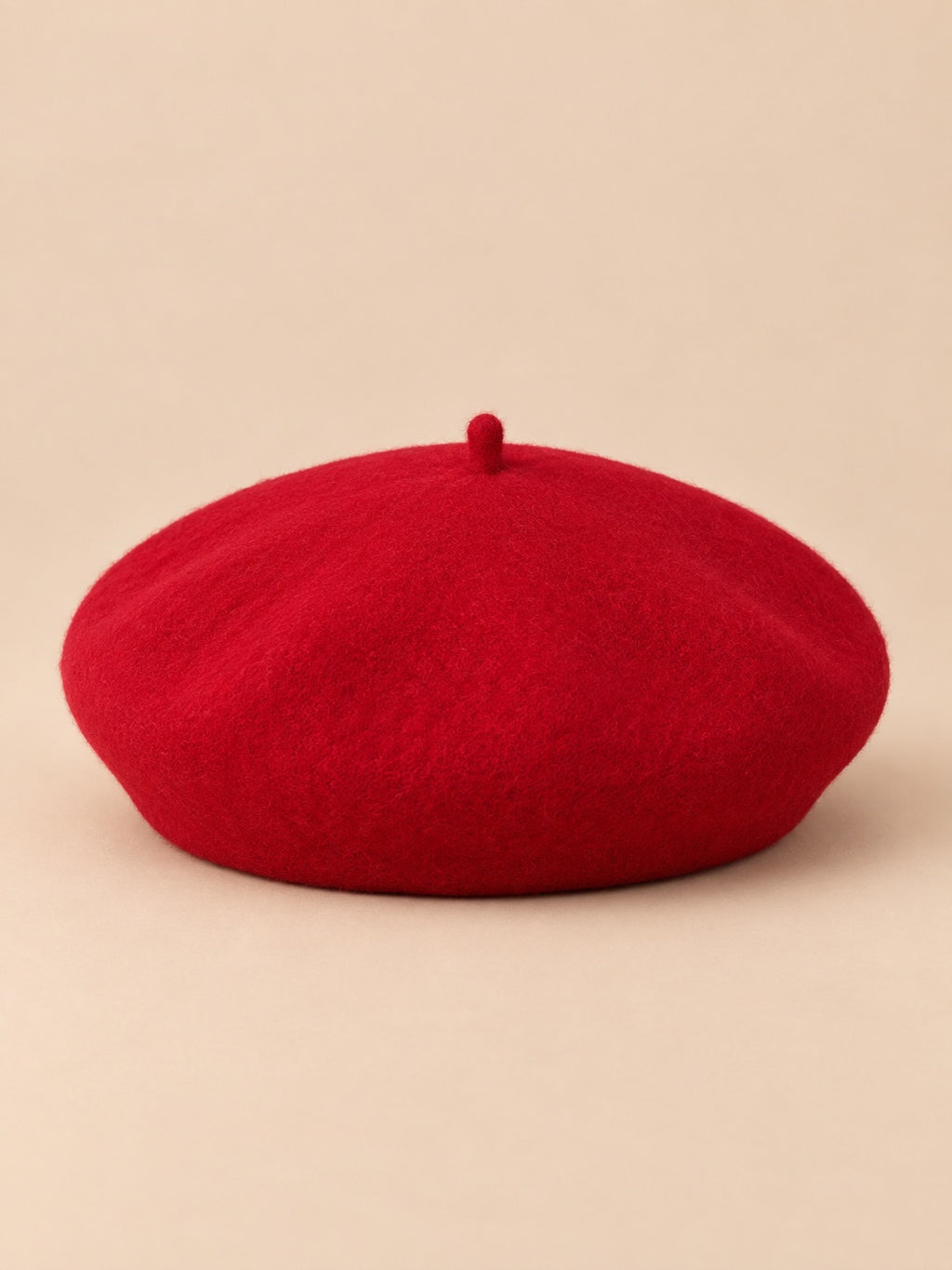 Béret français femme en pure laine rouge, vue de face sur fond beige