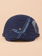 Béret gavroche en coton bleu marine, vue de face sur fond pêche sable