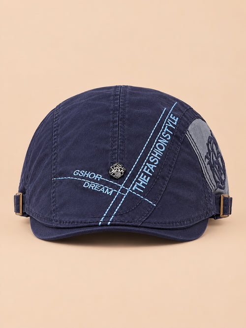 Béret gavroche en coton bleu marine, vue de face sur fond pêche sable