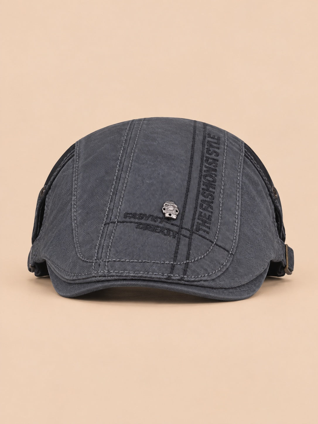 Béret gavroche en coton gris foncé version 2, vue de face sur fond pêche sable