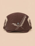 Gorra gavroche plana de algodón para todo el año, color marrón, vista frontal, sobre fondo color arena y melocotón