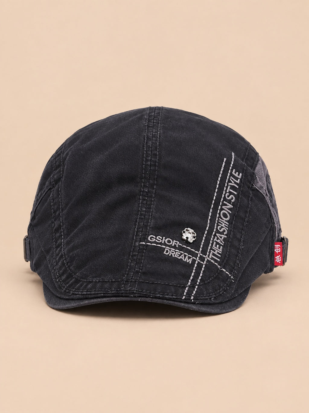 Gorra gavroche plana de algodón para todo el año, color negro, vista frontal, sobre fondo color arena y melocotón