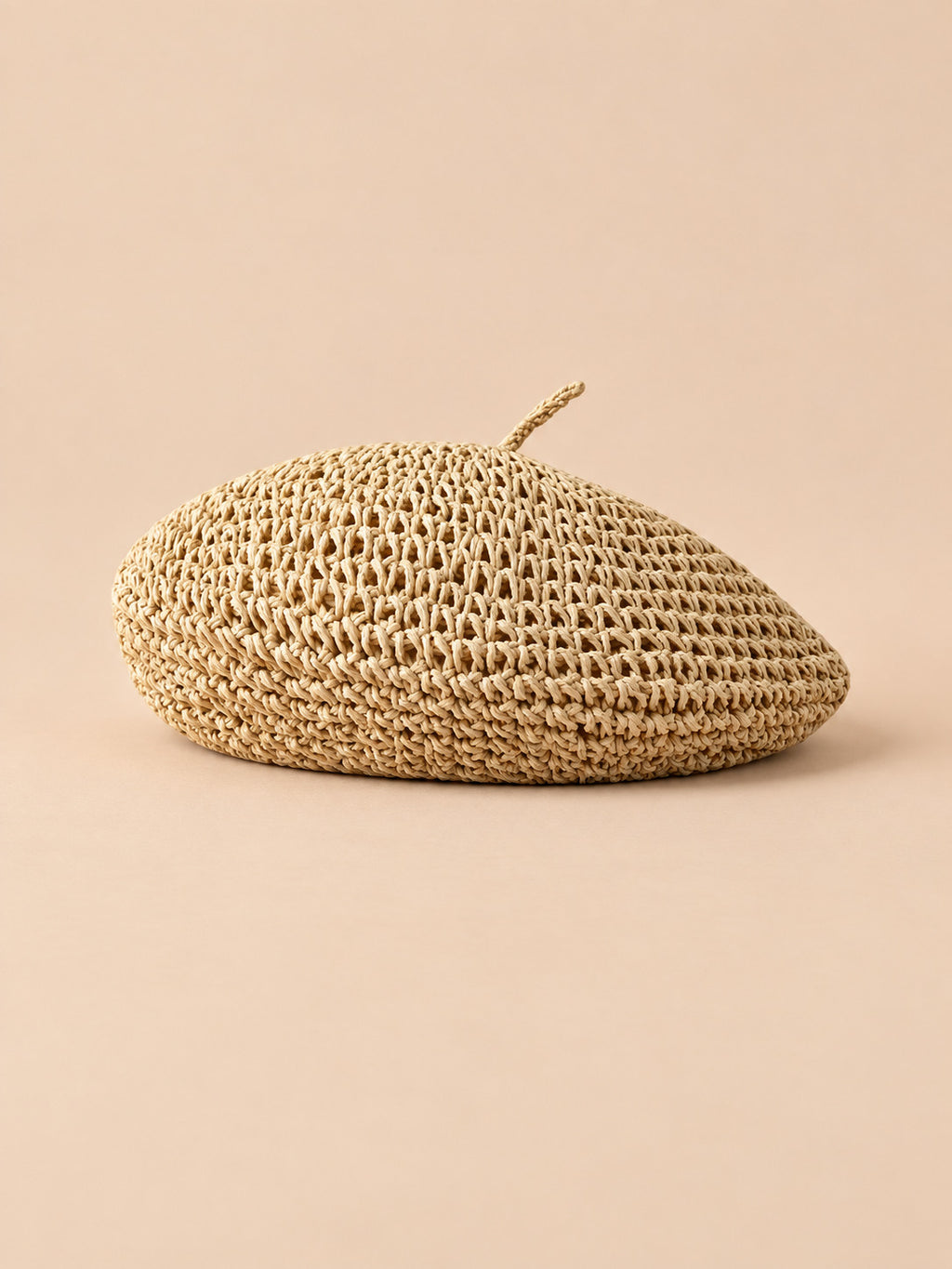 Béret plat effet paille Beige, vue de trois quarts sur fond pêche sable