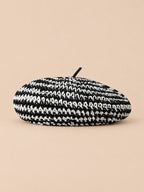 Béret plat effet paille Rayures noir et blanc, vue de face sur fond pêche sable