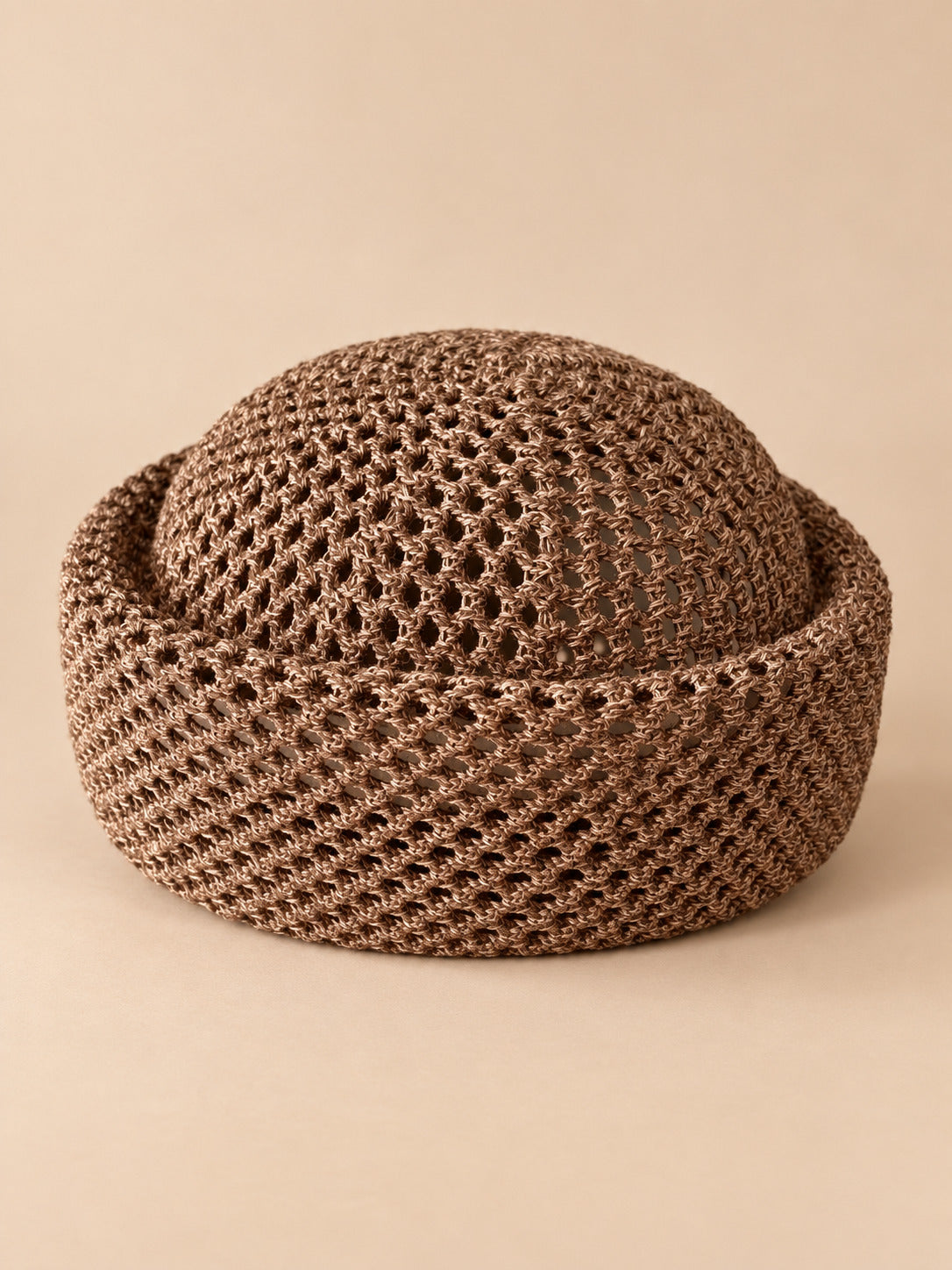 Béret résille ajouré marron 1, vue de face sur fond pêche sable