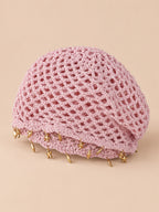 Béret rétro rose ajouré au crochet à franges d'étoiles dorées, vue trois quarts sur fond pêche sable