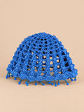 Béret crochet rétro bleu ajouré à franges de perles, vue de face sur fond pêche sable