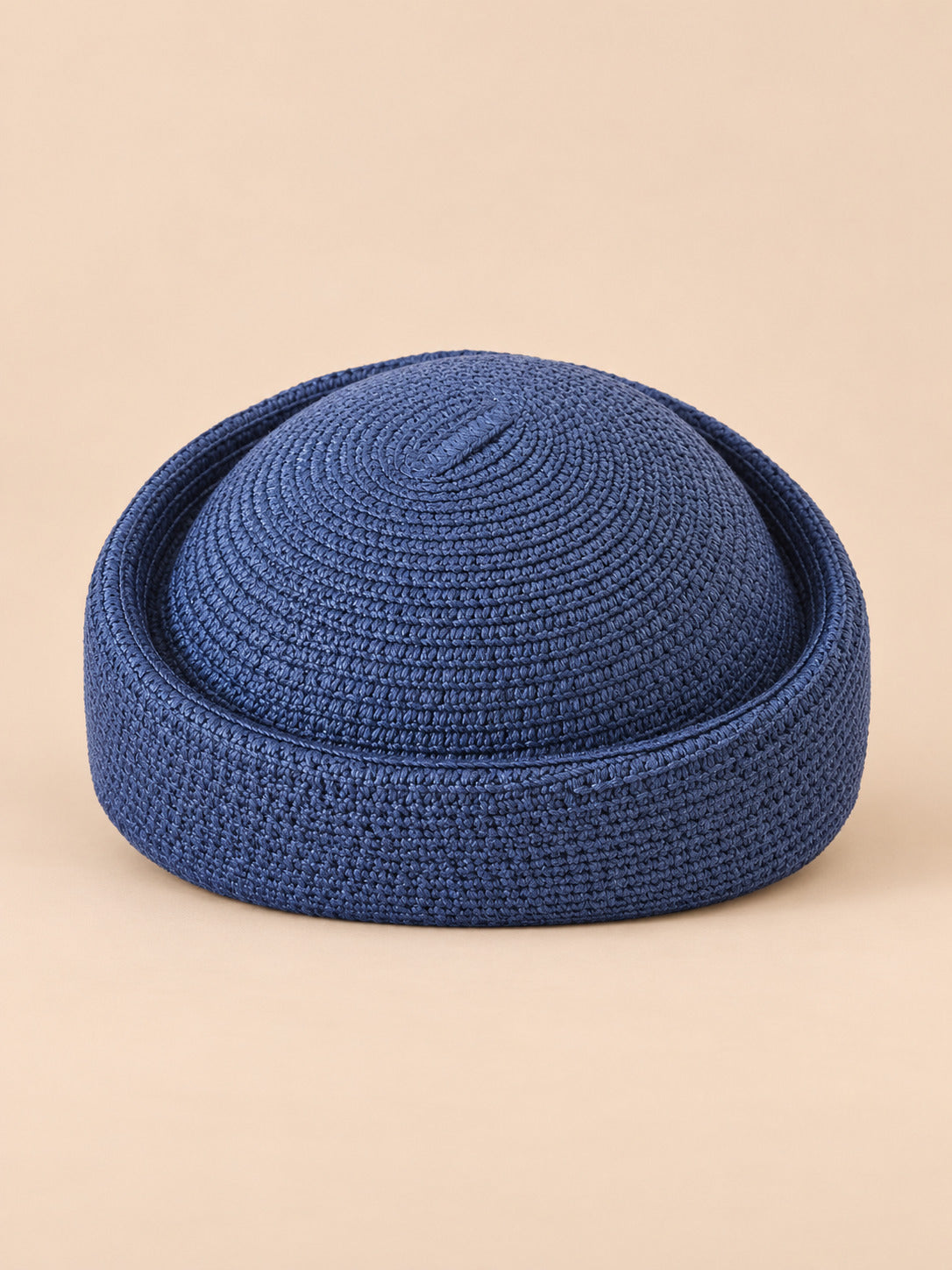 Béret rétro crochet Modèle 3 bleu marine, vue de face sur fond pêche sable