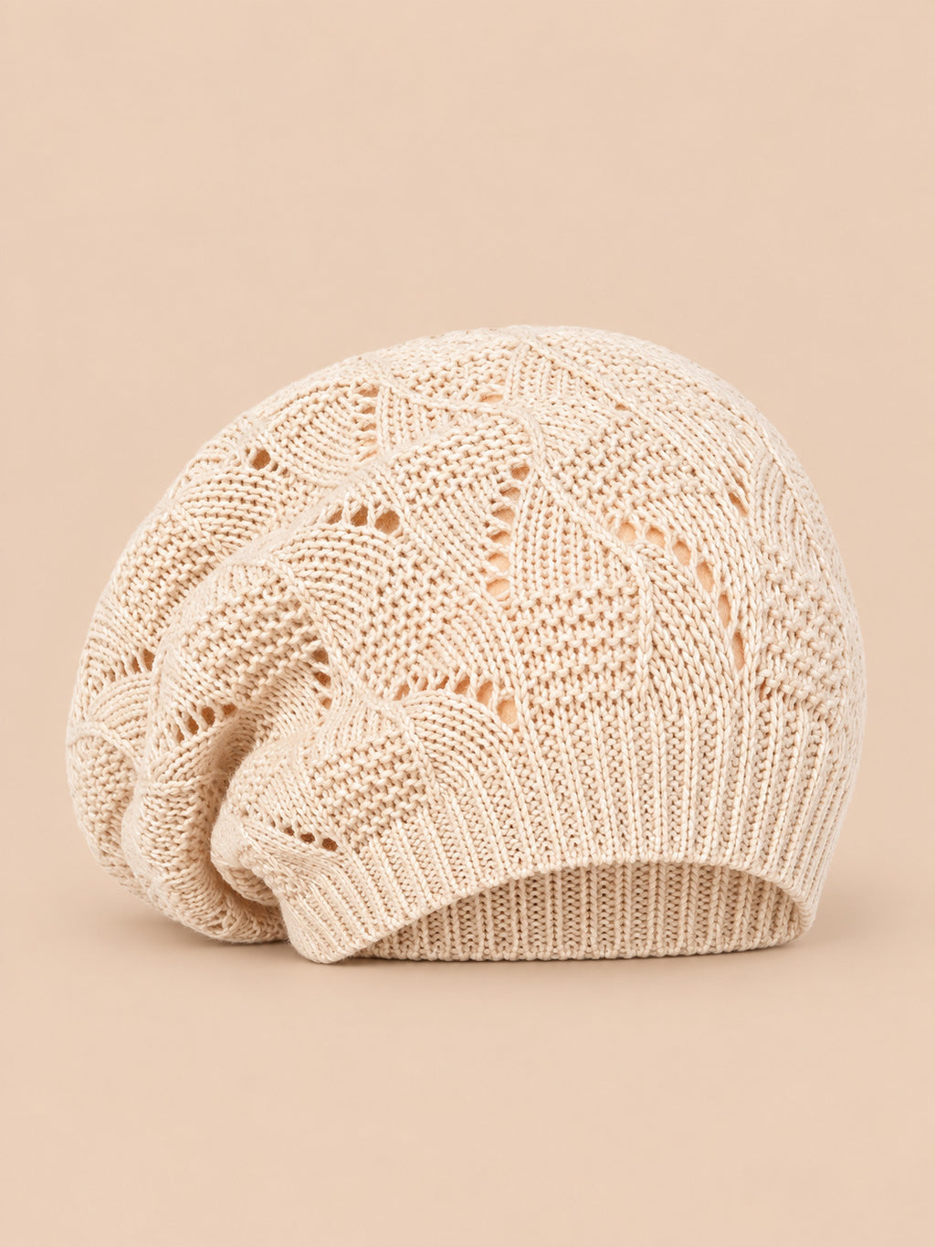 Bonnet béret torsadé ample beige, vue de face sur fond pêche sable