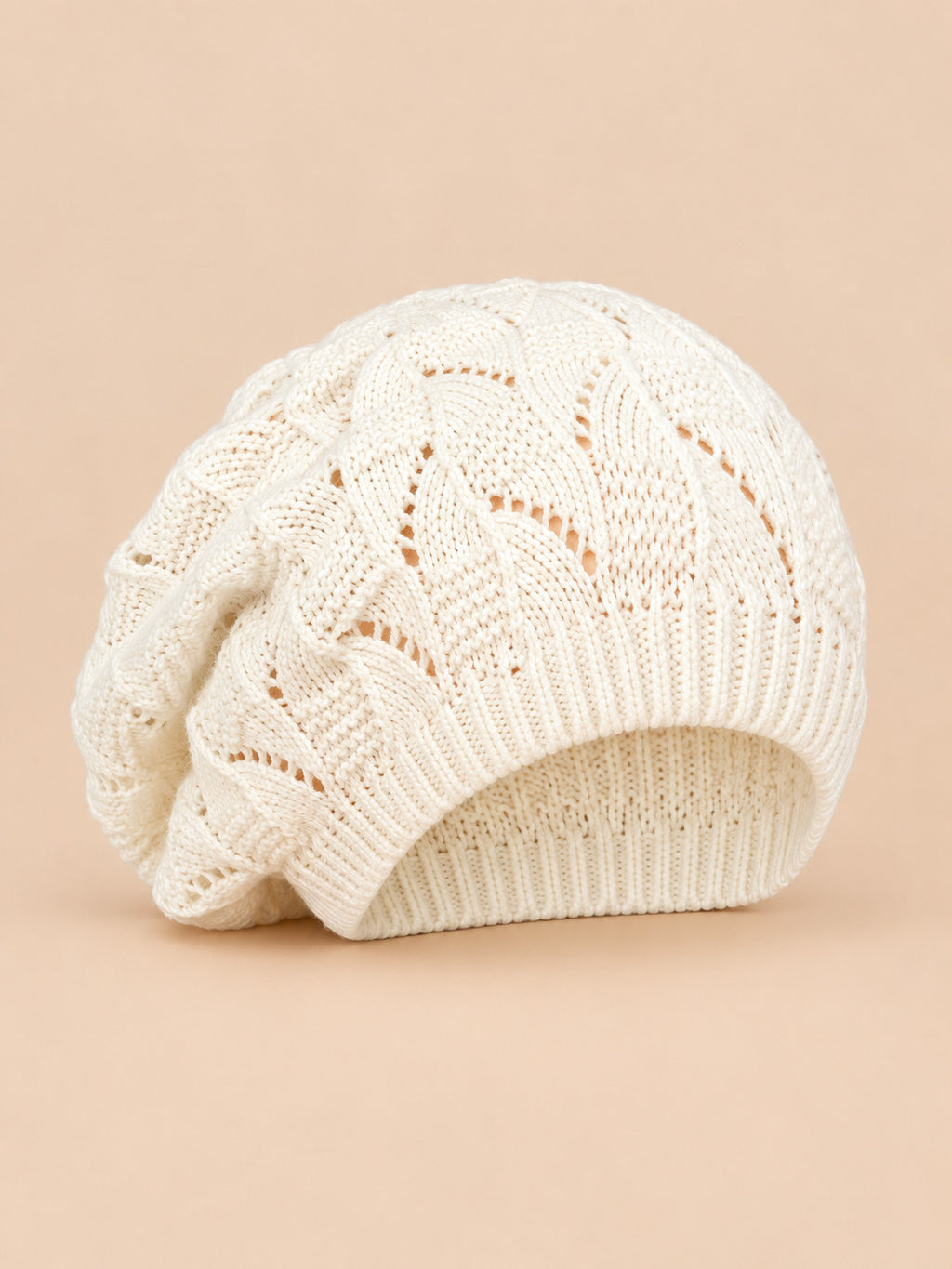 Bonnet béret torsadé ample blanc, vue de face sur fond pêche sable
