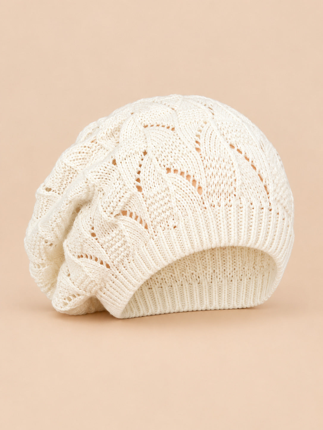 Bonnet béret torsadé ample blanc, vue de face sur fond pêche sable