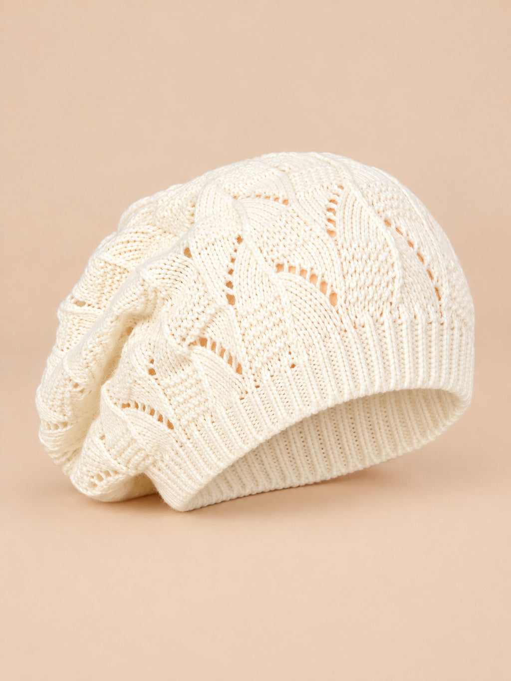 Bonnet béret torsadé ample blanc, vue de trois quarts sur fond pêche sable
