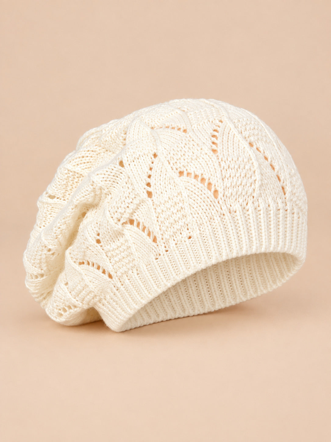 Bonnet béret torsadé ample blanc, vue de trois quarts sur fond pêche sable