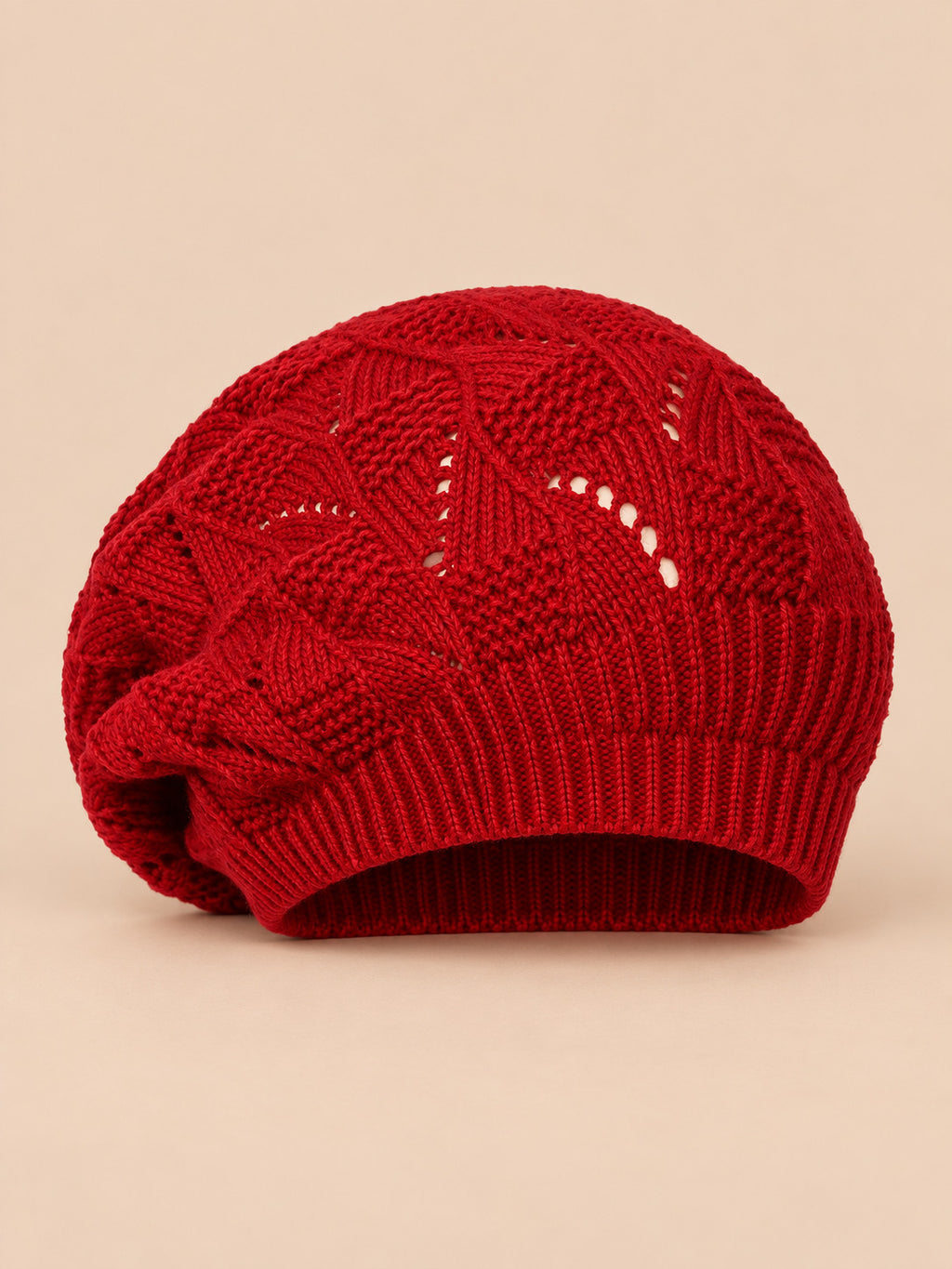 Bonnet béret torsadé ample bordeaux, vue de face sur fond pêche sable