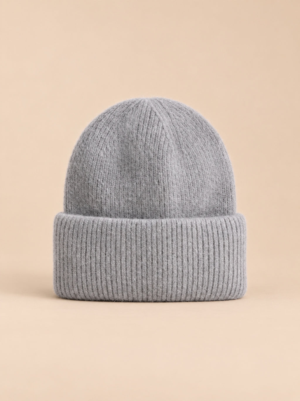 Gorro grueso de mujer de pelo de conejo y algodón, modelo 4, vista frontal, sobre fondo color arena y melocotón