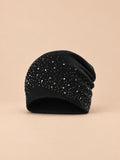 Bonnet femme tricoté à strass noir, vue de face sur fond pêche sable