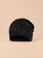 Bonnet femme tricoté à strass noir, vue de face sur fond pêche sable