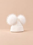 Bonnet double pompon, blanc, pompons assortis, vue de trois quarts sur fond pêche sable.