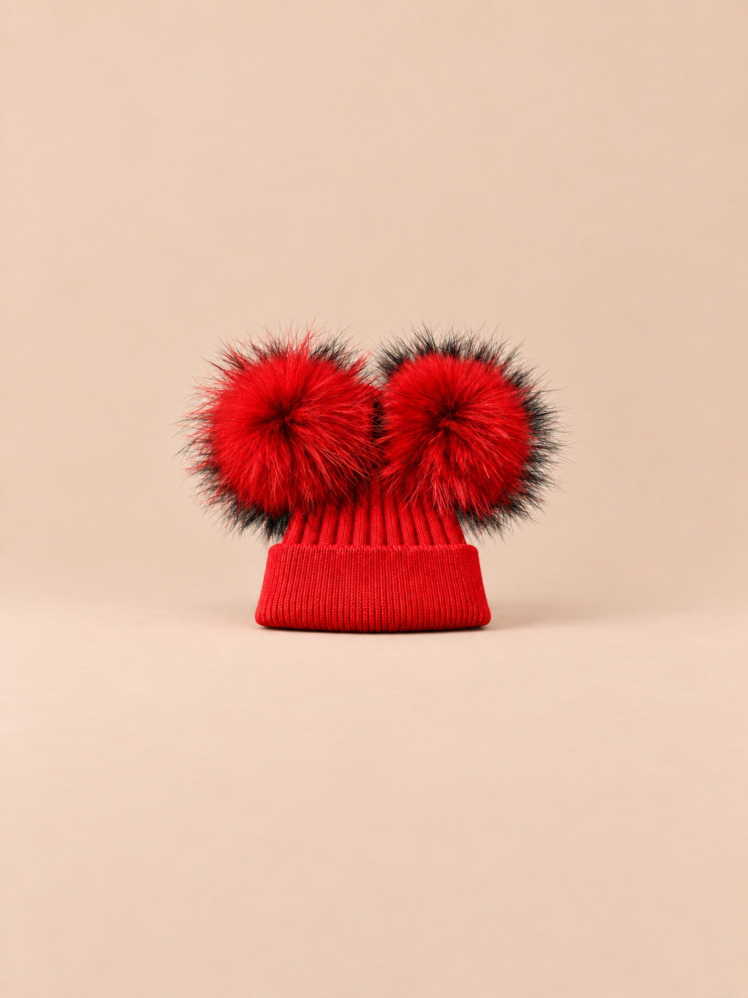 Bonnet double pompon, rouge, pompons assortis, vue de face sur fond pêche sable.