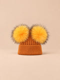 Bonnet double pompon, roux, pompons assortis, vue de face sur fond pêche sable.