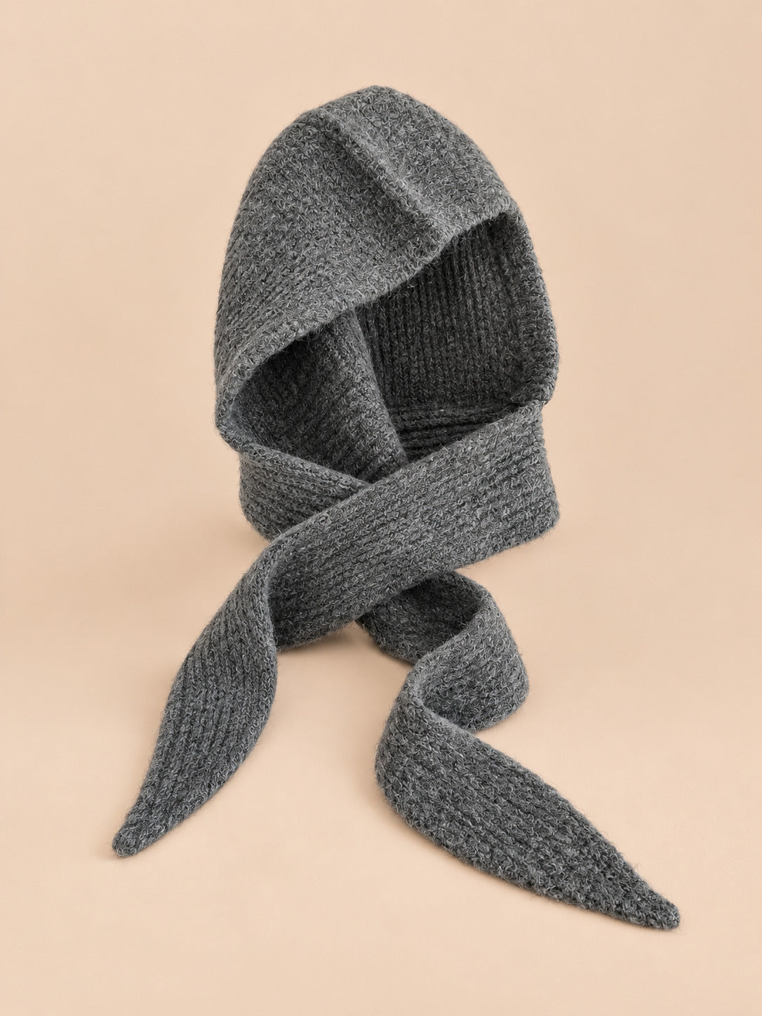 Cagoule bonnet-écharpe gris d en maille, vue de face sur fond pêche sable