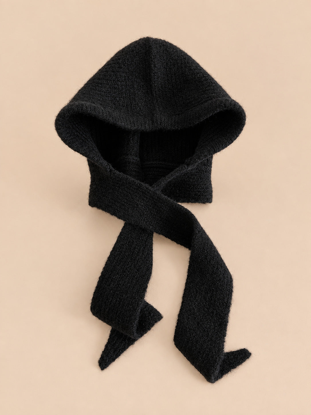 Cagoule bonnet-écharpe noir b en maille, vue de face sur fond pêche sable